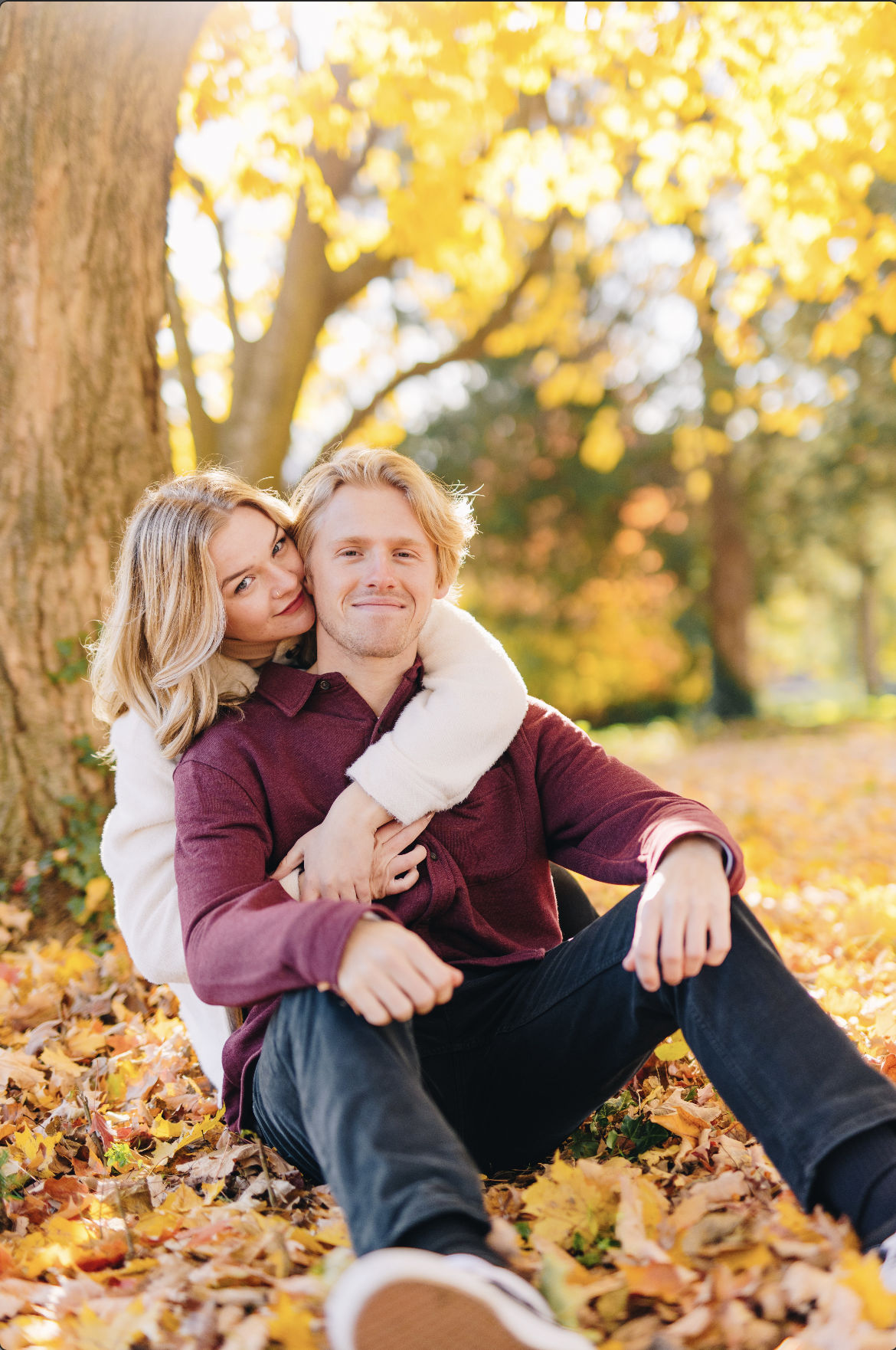Young couple smiling in autumn leaves
